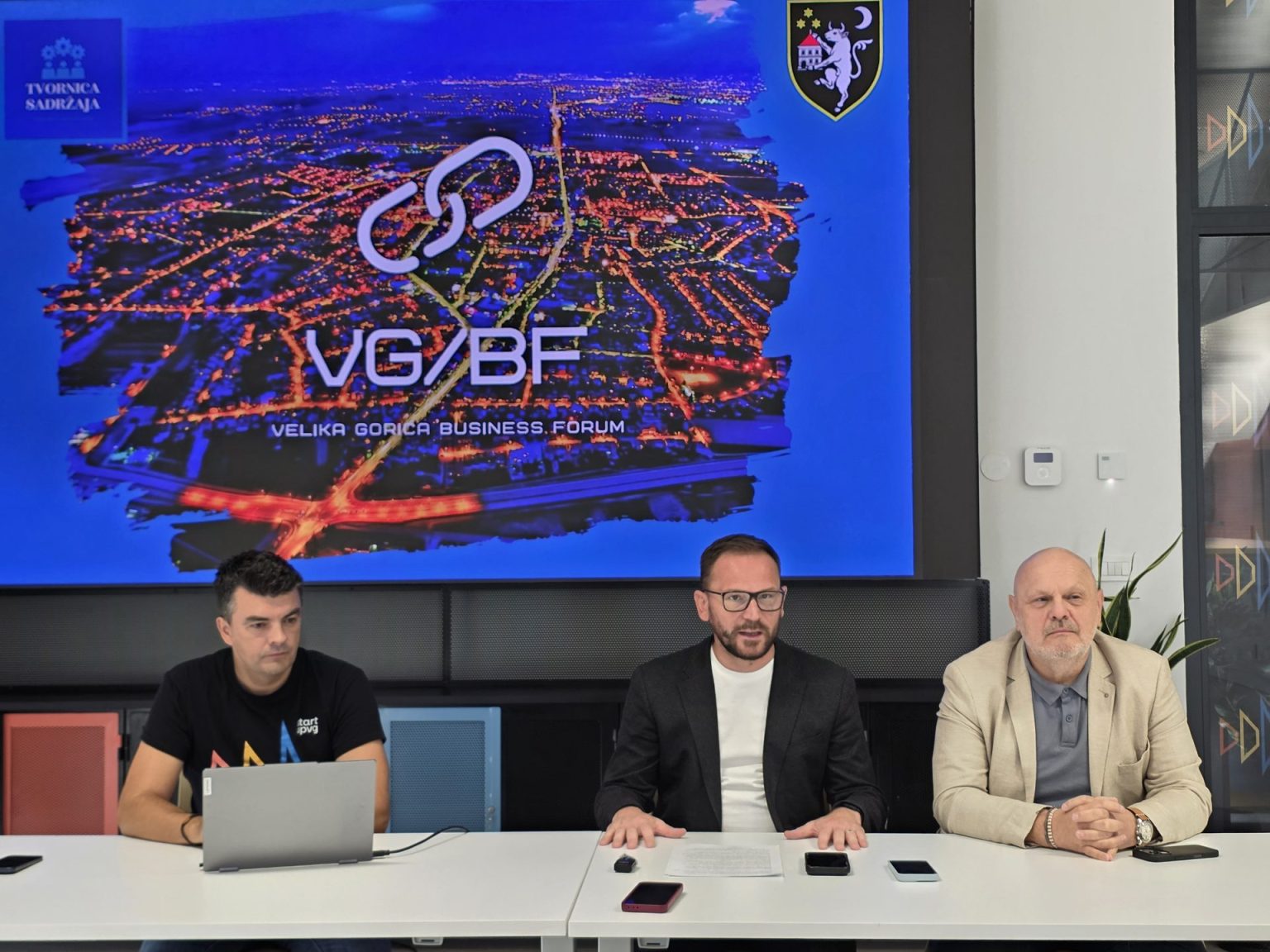 Tri muškarca sjede za konferencijskim stolom ispred ekrana s natpisom Velika Gorica Business Forum.