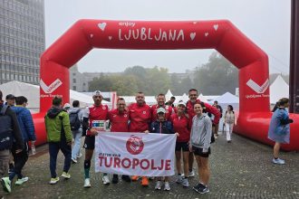 Članovi AK Turopolje s klupskom zastavom ispod luka Ljubljana.