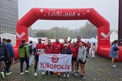 Članovi AK Turopolje s klupskom zastavom ispod luka Ljubljana.